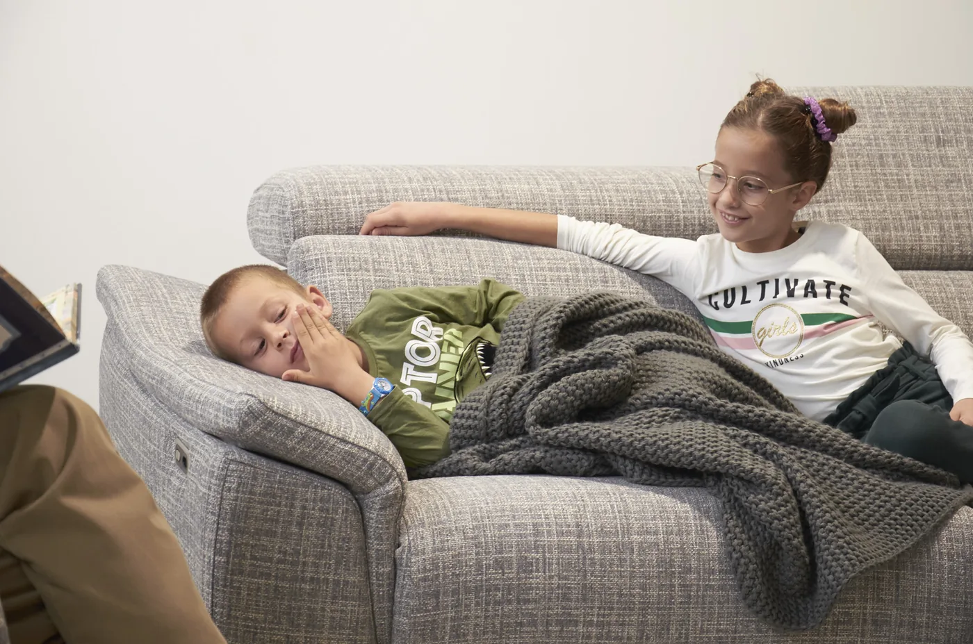 Niños descansando en un sofá gris